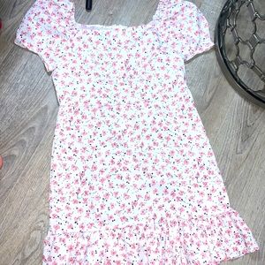 Has zipper on back. The design is pink flowers. And has puffy sleeves.